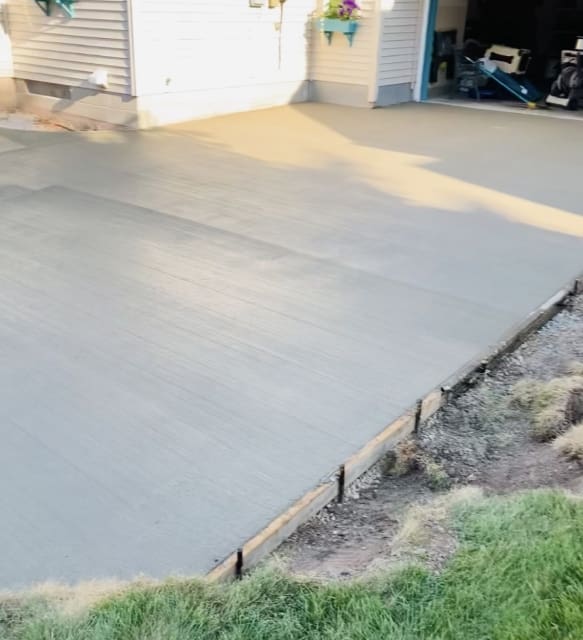 A concrete slab with grass growing around it.